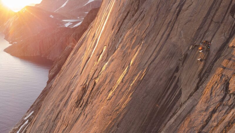 climbers on Greenland wall at dawn