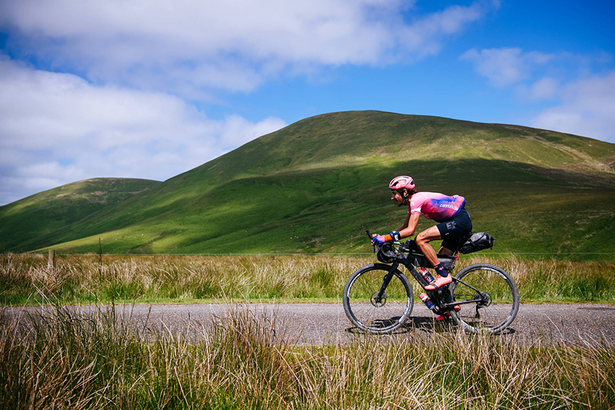 Lachlan Morton cycles on rural road