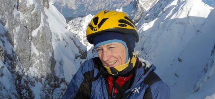 Close shot of Nives Meroi while climbing in altitude, with a helmet but no sun glasses