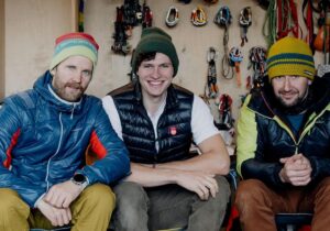 The climbers in front of a wall with climbing gear