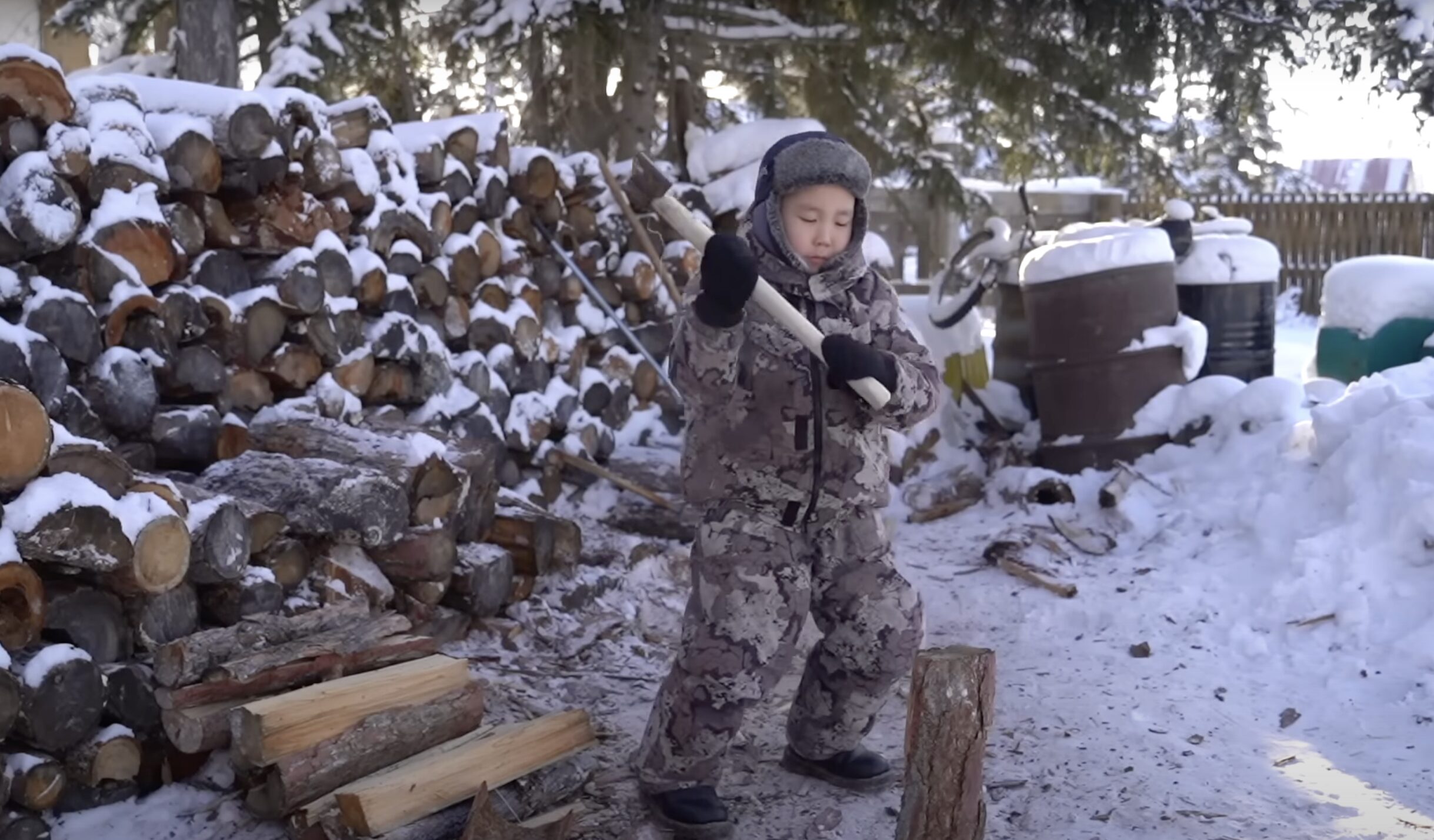 A boy chops wood in northern Russia