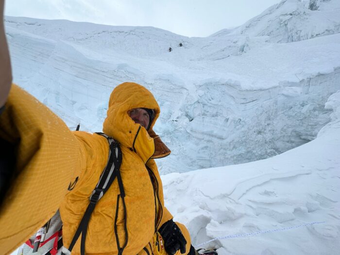 Moro takes a selfie on Manaslu seracs and tiny climbers in backdrop.