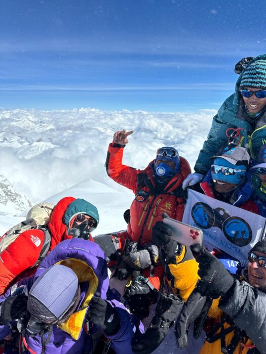 Climbers celebrate a summit above the clouds