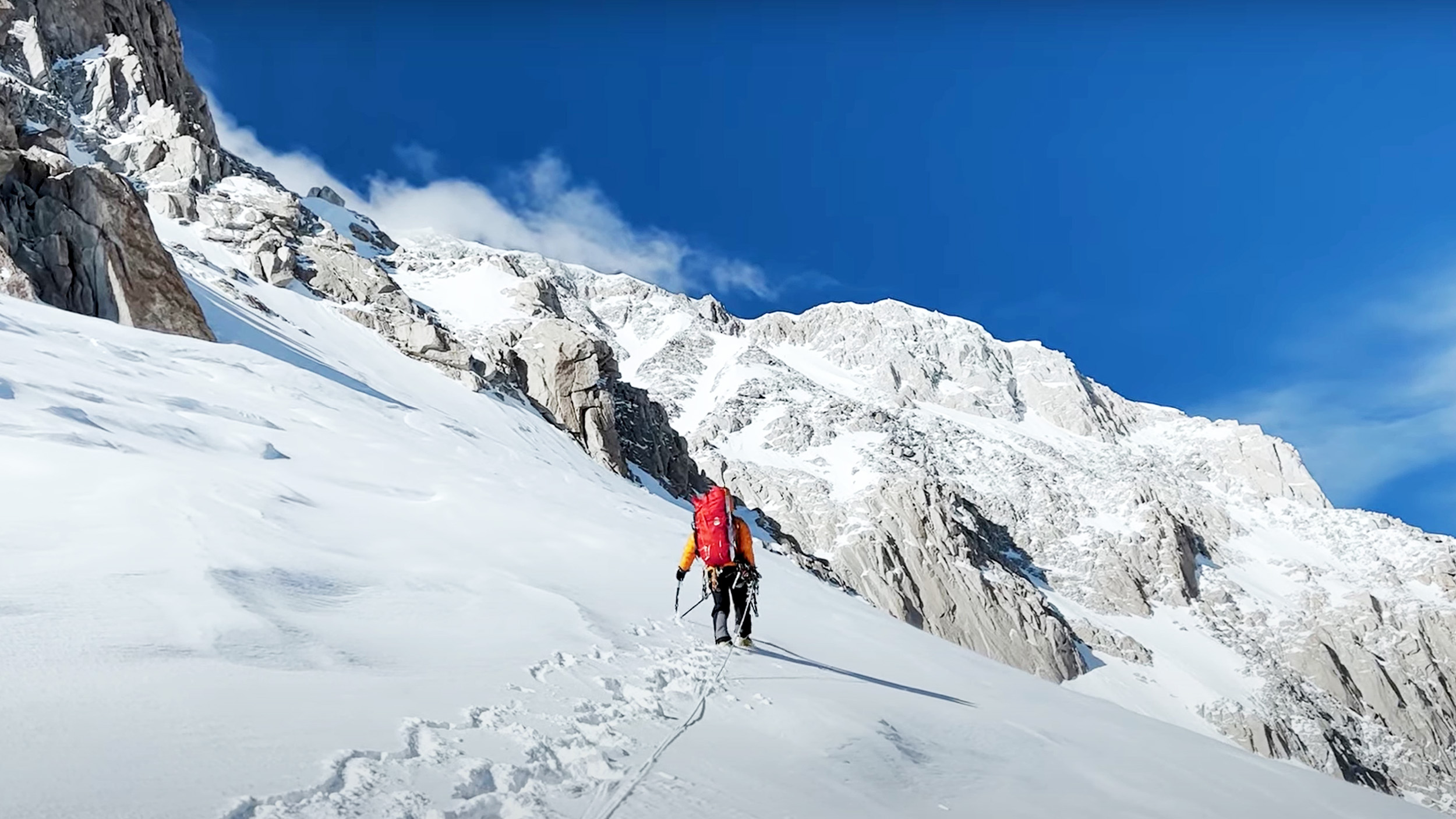 a woman climbs a snowy peak