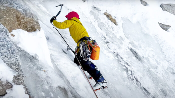 a woman climbs with ice axes