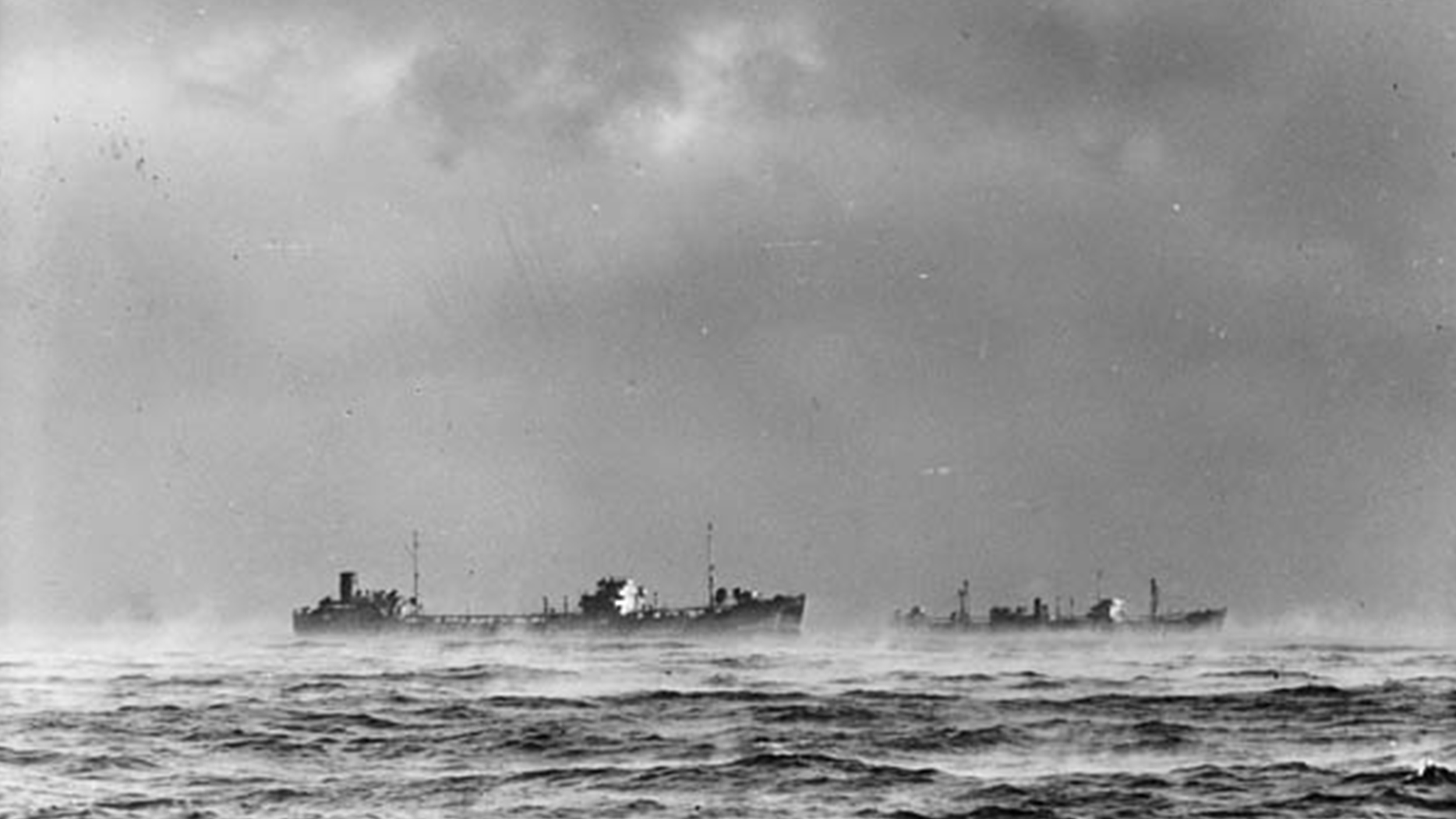 a black and white photo of two merchant ships circa 1940