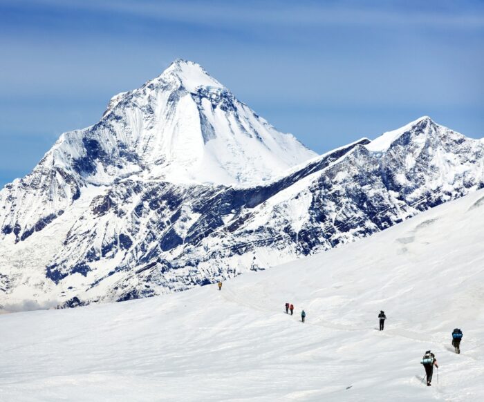 Trekkers at Damphus pass, on a snow slope, near Dhaulagiri