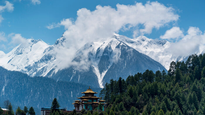 A Tibetan monastery with mountains in the background 