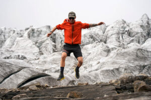 Runners jumping over rocks in big mountains