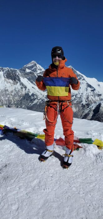 Balavanov stands with an Ukrainian flag on the summit of Ama Dablam