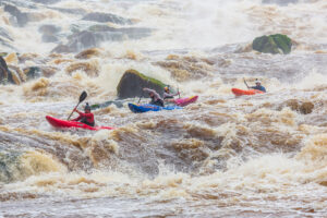 four kayakers in crazy whitewater