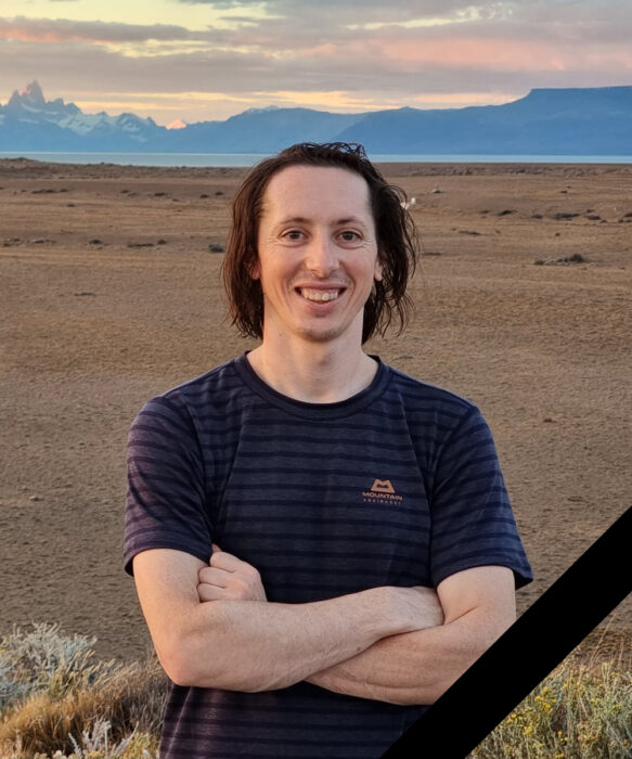 File image of Huserka in a t-shirt with a wide plain behind and mountains in background.