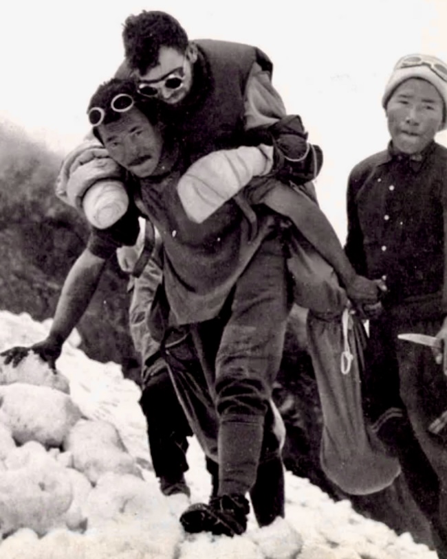 Maurice Herzog is carried down Annapurna by the Sherpas.