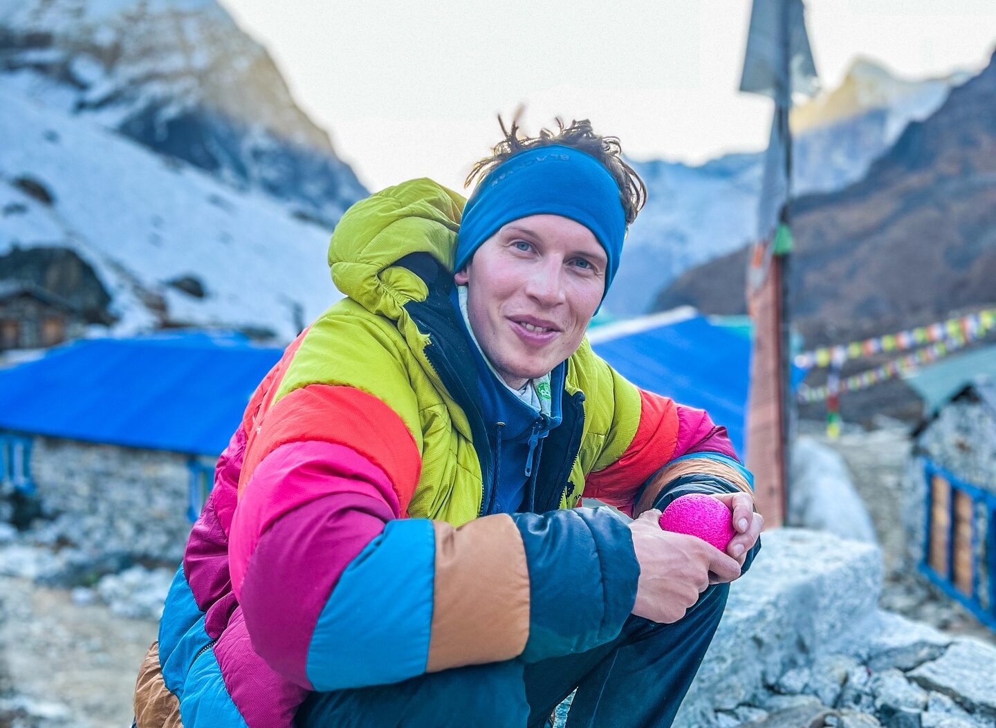 Kobusch smiles while sitting on a stone fence in a Khumbu village.