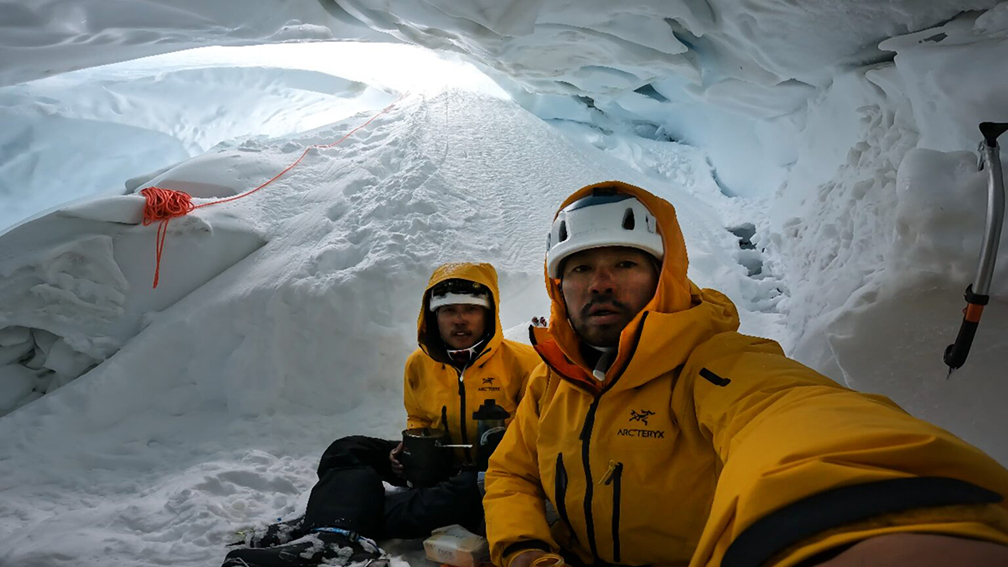 the two climbers in yellow inside a crevasse