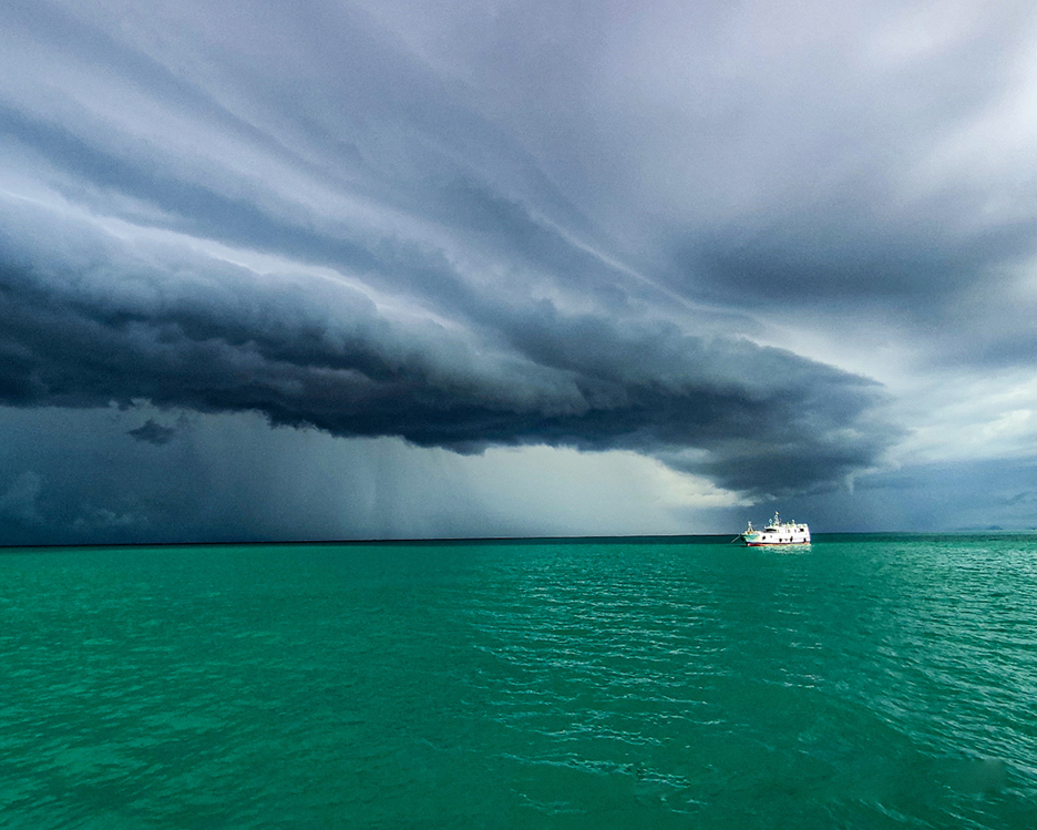 storm over green ocean with boat