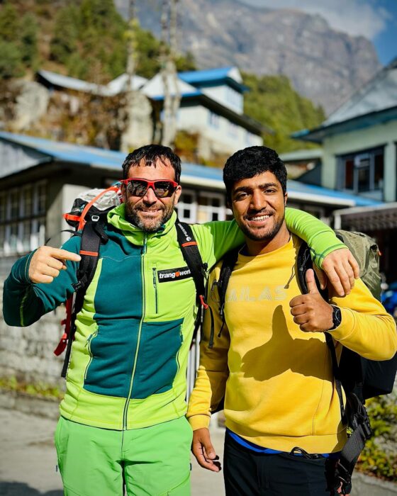 The climbers hold each other shoulders and gives thumbs-up in a sunny day in Nepal's Khumbu.