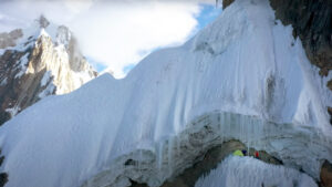 two people camp underneath an ice roof