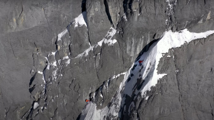 two men climb a mountain