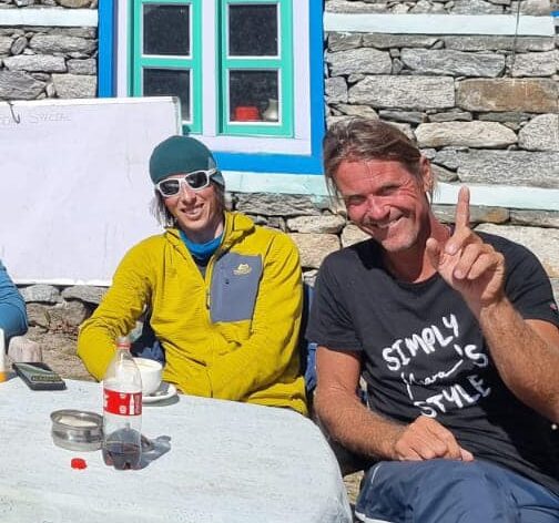 the climbers sitting at a table in the open 