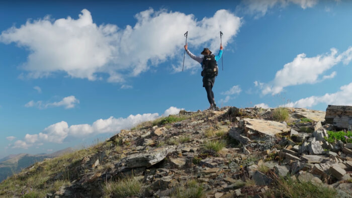 a man stands on top of a rocky hill