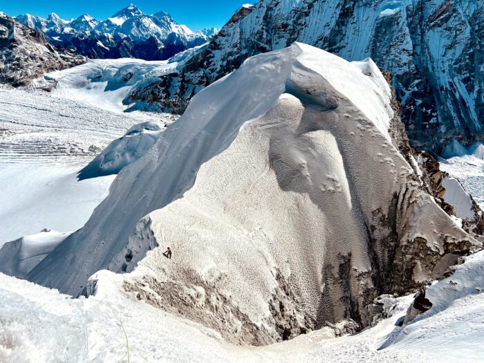 a tiny climber on a snow meringue-line summit