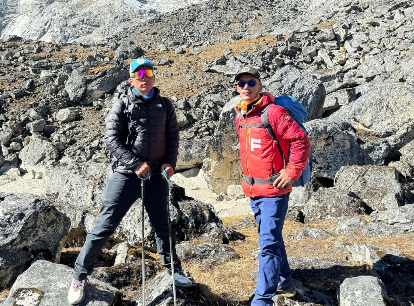 The sherpa brothers pose in a trail on rocky mountain terrain