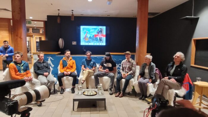 the climbers sitting in a semi circle with microphones.