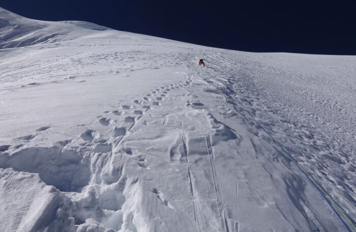 A climber on an endsless slope of snow