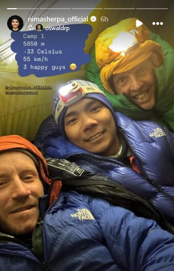 The climbers in down suits inside a tent