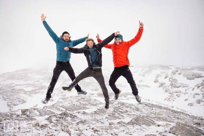 The climbers on a foggy day, jumping on snowy terrain