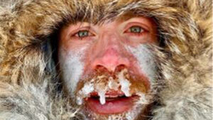 a man in a hooded parka with ice frozen to his mustache