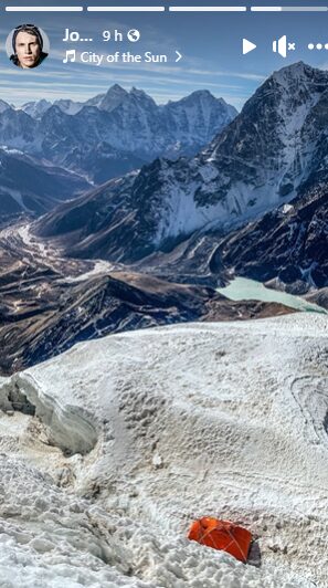 A tent on a snow shoulder of a mountain