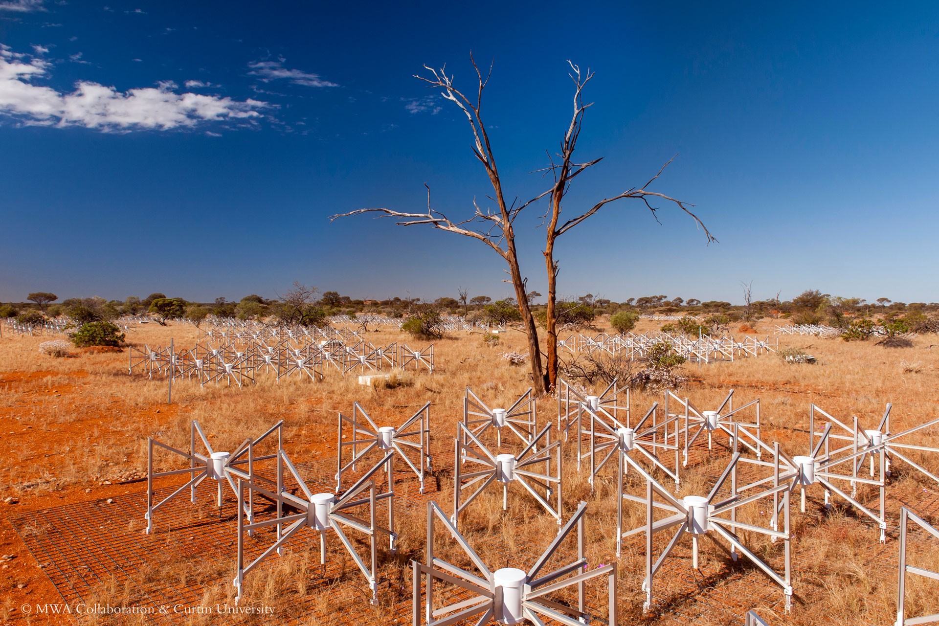 A collection of radio antennae sit in the outback.