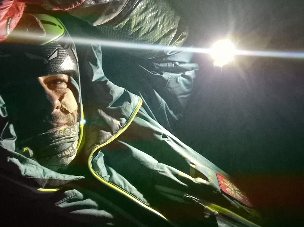 climber in tent in dark with headlamp