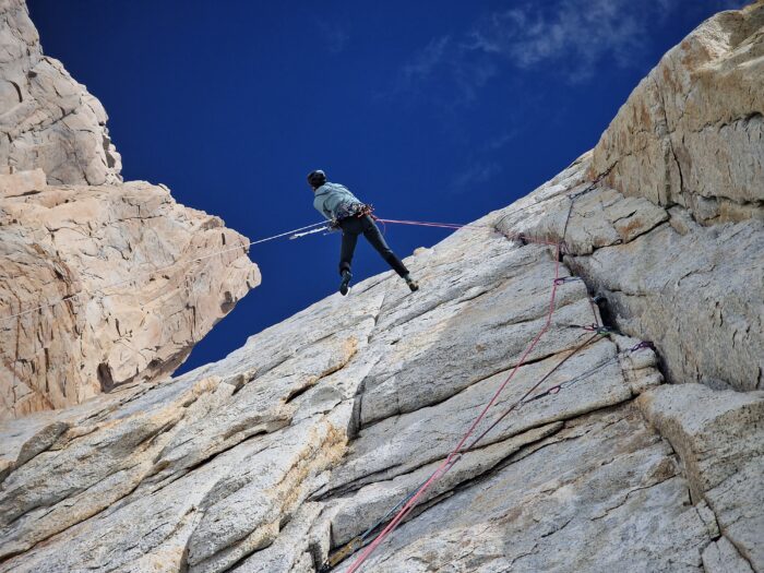 a climber on a traverse in a patagonia granite wall