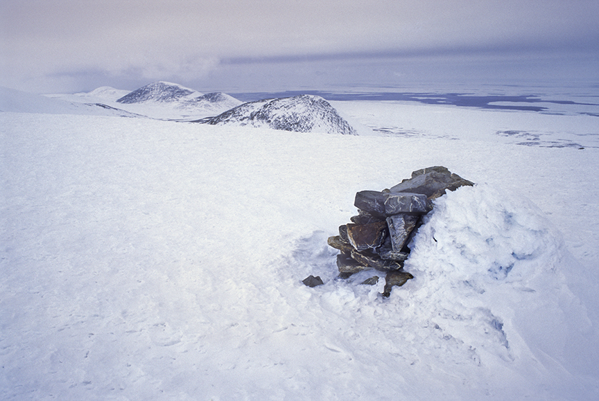 Pile of rocks half-buried in snow.