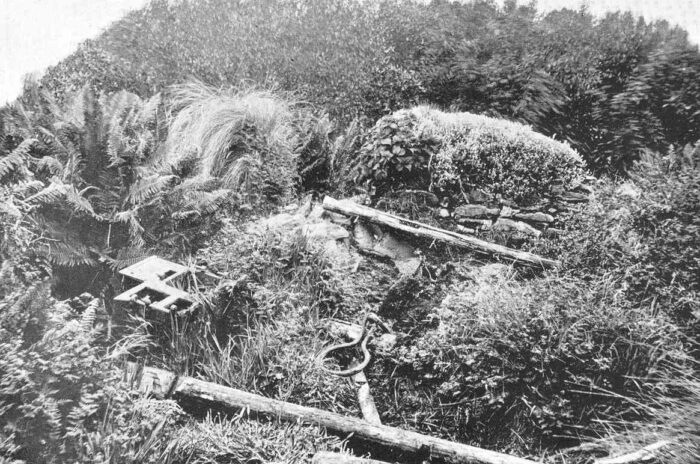 a black and white photo of a hut in shambles