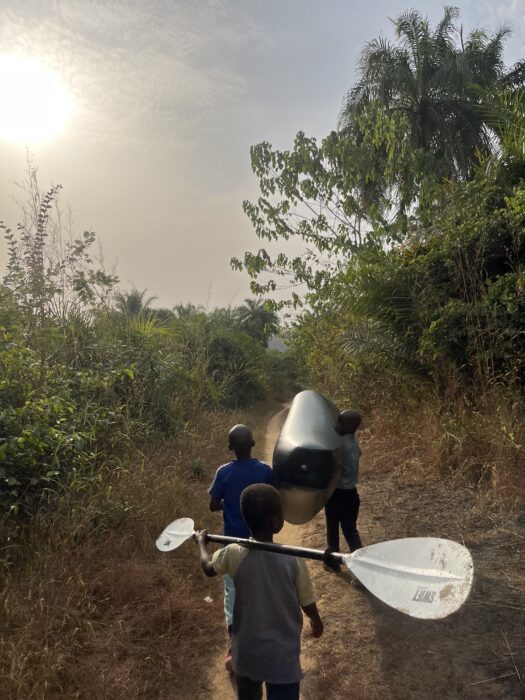 children carry a boat and a paddle