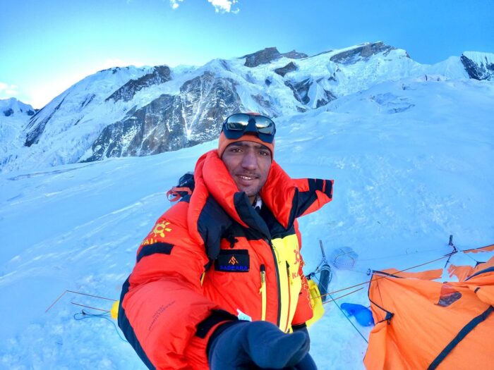 Sajid Sadpara by a tent on a snowy field on Annapurna