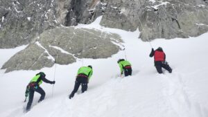 rescuers use poles to look for bodies buried in the snow