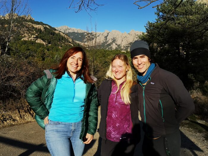 Three people in la Pedriza, a landscape of pine trees and granite boulders