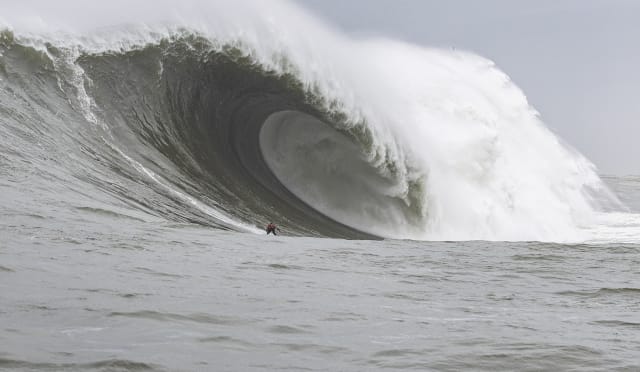 Alo Slebir rides an enormous wave at Mavericks Beach.