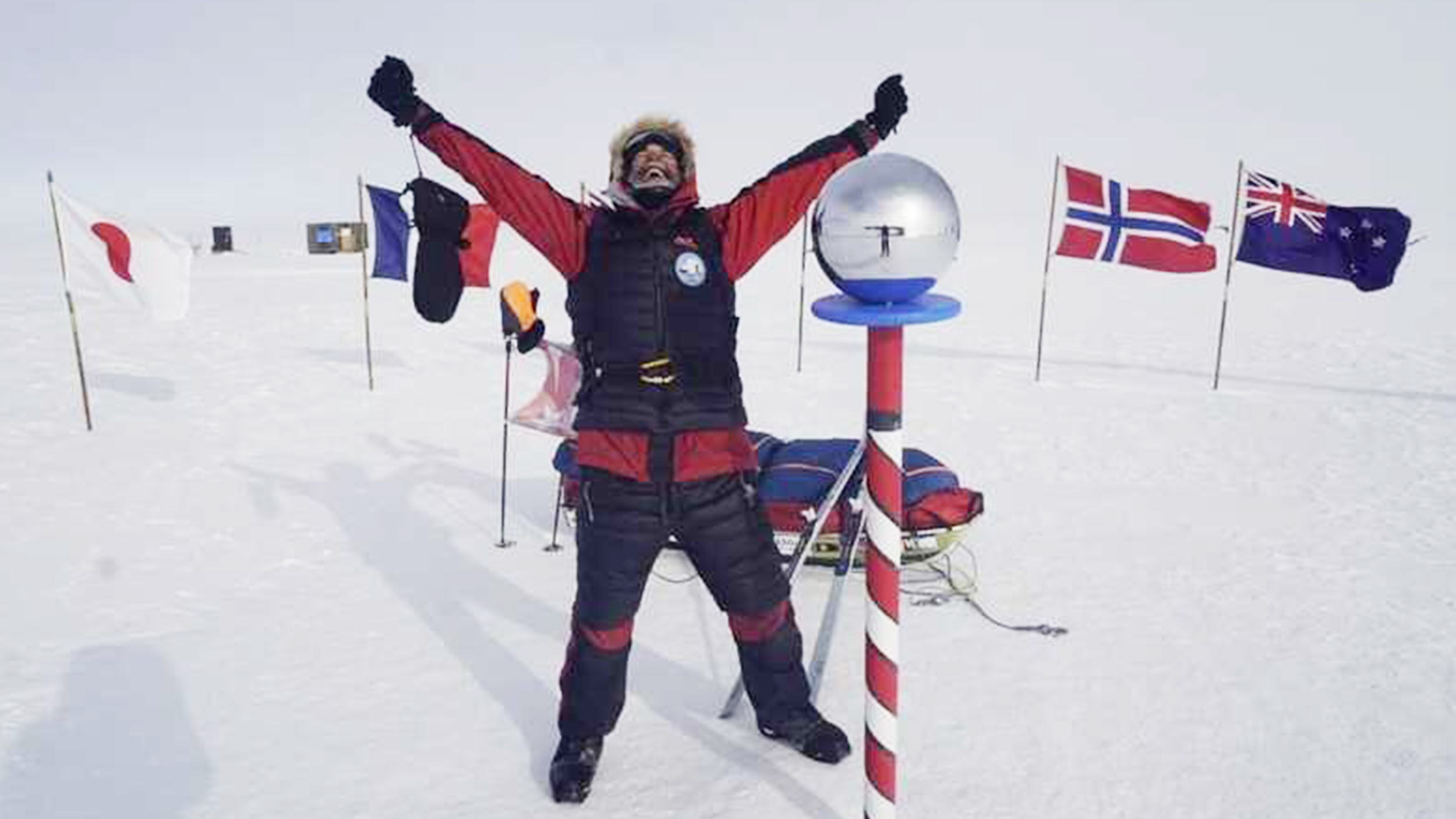 a man celebrates at the south pole