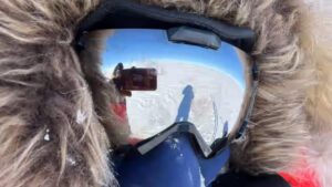 a man in a polar hood and goggles takes a selfie