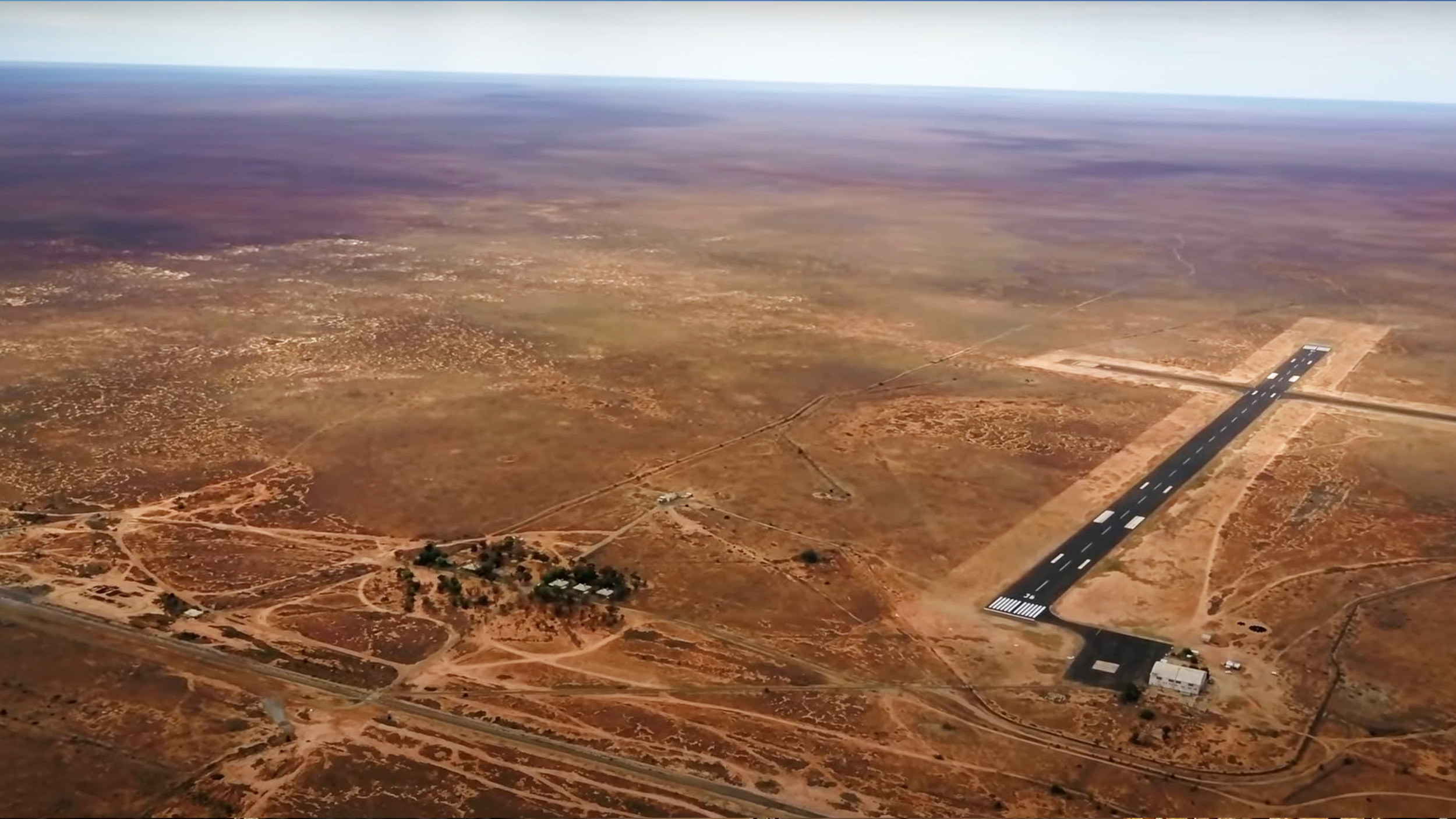 a runway and some cottages as seen from high in the air