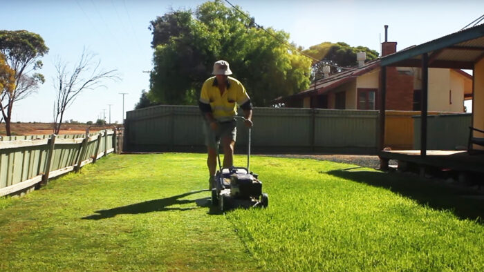 a man mows a lawn