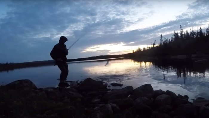 a man fishing at sunset