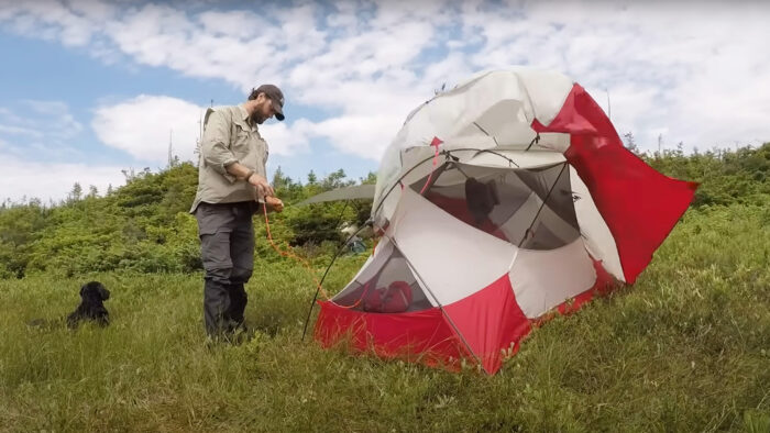 a man sets up a tent