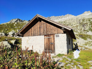 a mountain hut below a rocky ridge